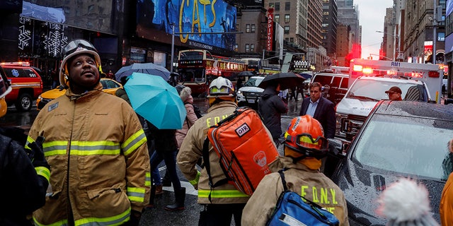 Fire Department of New York (FDNY) personnel and New York Police Department (NYPD) officers work at the scene as a woman was reported dead after debris fell on her near Times Square 