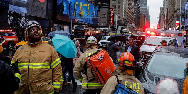 Fire Department of New York (FDNY) personnel and New York Police Department (NYPD) officers work at the scene as a woman was reported dead after debris fell on her near Times Square