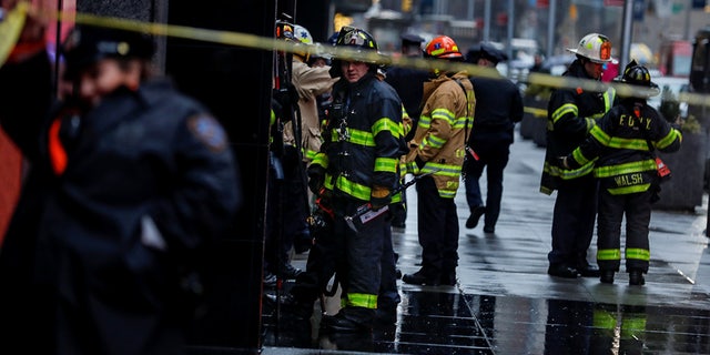 Fire Department of New York (FDNY) personnel and New York Police Department (NYPD) officers work at the scene as a woman was reported dead after debris fell on her near Times Square in Manhattan, New York, U.S., December 17, 2019. 