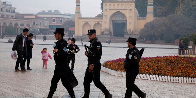 Uighur security personnel patrol near the Id Kah Mosque in Kashgar in western China's Xinjiang region. Classified documents, leaked to a consortium of news organizations, lay out the Chinese government's deliberate strategy to lock up ethnic minorities to rewire their thoughts and even the language they speak. 