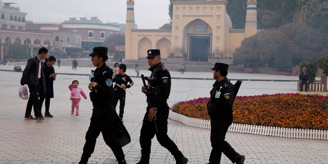 In this Nov. 4, 2017 file photo, Uighur security personnel patrol near the Id Kah Mosque in Kashgar in western China's Xinjiang region. Classified documents, leaked to a consortium of news organizations, lay out the Chinese government's deliberate strategy to lock up ethnic minorities to rewire their thoughts and even the language they speak. (AP Photo/File)