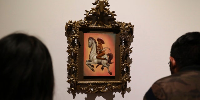 The painting shows 1910-17 Mexican revolutionary hero Emiliano Zapata nude, wearing high heels and a pink, broad-brimmed hat, straddling a horse. (AP Photo/Eduardo Verdugo)