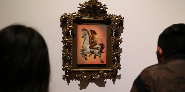 The painting shows 1910-17 Mexican revolutionary hero Emiliano Zapata nude, wearing high heels and a pink, broad-brimmed hat, straddling a horse. (AP Photo/Eduardo Verdugo)