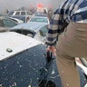 A person climbs over crashed cars.