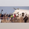 Rescuers assist on the site of a plane which crashed near Almaty International Airport, outside Almaty, Kazakhstan, Friday, Dec. 27, 2019. 