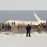 Police guard as rescuers work on the side of the plane.