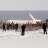 Police stand guard as rescuers assist on the site of a plane crash near Almaty International Airport, outside Almaty, Kazakhstan, Friday, Dec. 27, 2019.