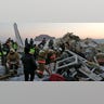 Police and rescuers work on the side of a plane crash near Almaty International Airport.