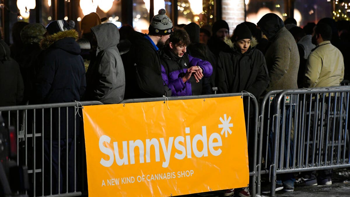 A long line of people brave the cold as they wait to be the first in Illinois to purchase recreational marijuana at Sunnyside dispensary Wednesday, Jan. 1, 2020, in Chicago. (AP Photo/Paul Beaty)