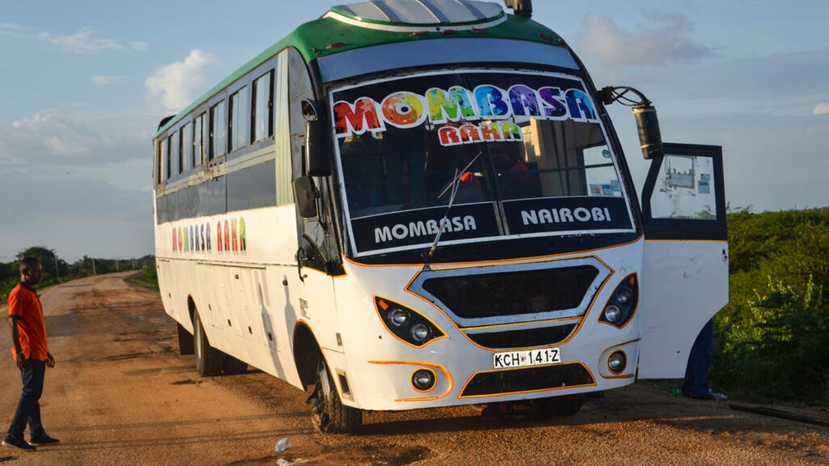 A man looks at a bus which was ambushed by gunmen in the Nyongoro area of Lamu county, near the Indian Ocean coast of Kenya Thursday, Jan. 2, 2020.