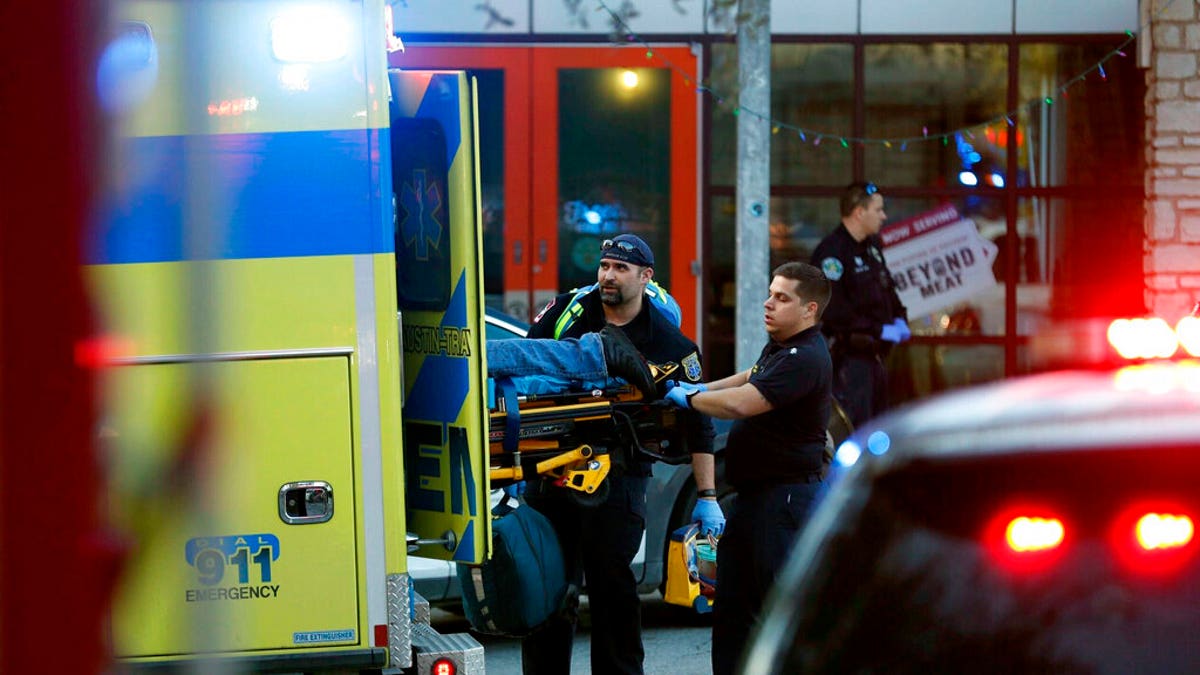 Paramedics transport a stabbing victim as Austin Police secure the area of a shopping complex in Austin, Texas, on Friday, Jan. 3, 2020.