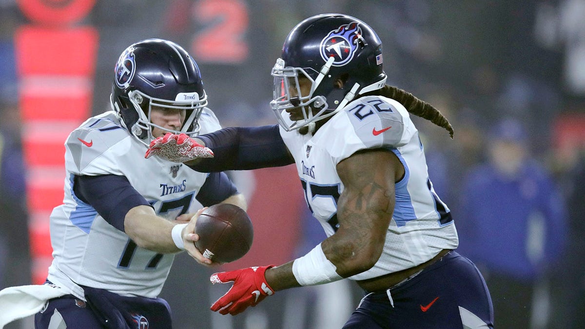 Tennessee Titans quarterback Ryan Tannehill, left, hands off to running back Derrick Henry in the first half of an NFL wild-card playoff football game against the New England Patriots, Saturday, Jan. 4, 2020, in Foxborough, Mass. (AP Photo/Charles Krupa)