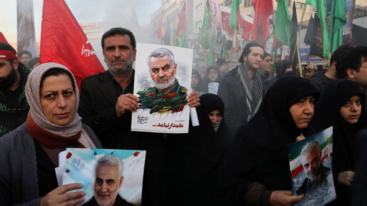 Mourners holding posters of Iranian Gen. Qassem Soleimani attend a funeral ceremony for him and his comrades, who were killed in Iraq in a U.S. drone strike on Friday, at the Enqelab-e-Eslami (Islamic Revolution) Square in Tehran, Iran, Monday, Jan. 6, 2020. (AP Photo/Ebrahim Noroozi)