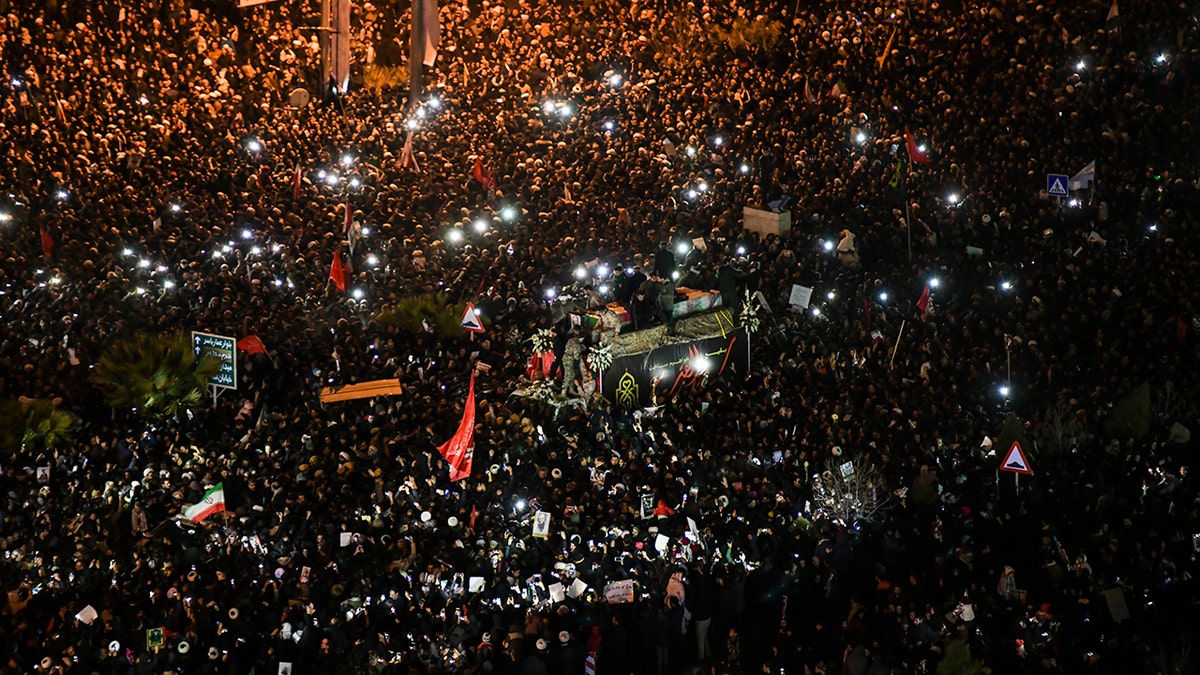 Mourners surround a truck carrying the flag draped coffins of Gen. Qassem Soleimani and his comrades in the holy city of Qom south of the capital Tehran, Iran, Monday, Jan. 6, 2020. (Amir Hesaminejad/Tasnim News Agency via AP)