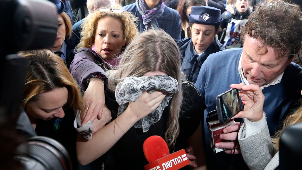 A 19-year-old British woman, center, that was found guilty of making up claims she was raped by up to 12 Israelis arrives at Famagusta District Court for sentencing on Tuesday, Jan. 7, 2020. The woman was found guilty on a charge of public mischief which carries a maximum 1,700 euro fine and one year in jail. The woman insists she was raped and was coerced by investigators to retract her claim. (AP Photo/Petros Karadjias)