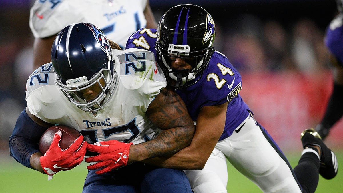 Baltimore Ravens cornerback Marcus Peters (24) hits Tennessee Titans running back Derrick Henry (22) during an NFL divisional playoff football game, Saturday, Jan. 11, 2020, in Baltimore. (Associated Press)
