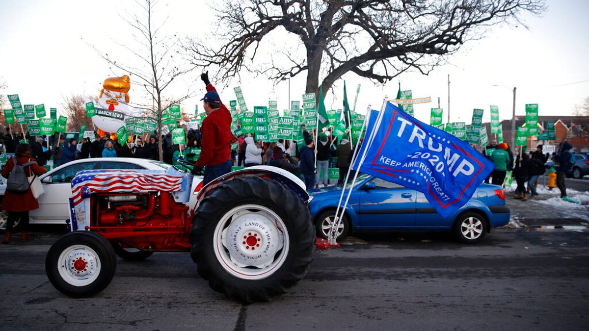 A Trump supporter rides by Democratic presidential candidate Sen. Amy Klobuchar, D-Minn., rally before a Democratic presidential primary debate Tuesday, Jan. 14, 2020, hosted by CNN and the Des Moines Register in Des Moines, Iowa. (AP Photo/Patrick Semansky)