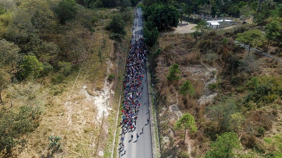 Migrants walk along a highway in hopes of reaching the distant United States, near Agua Caliente, Guatemala on Thursday near the border with Honduras. Hundreds of Honduran migrants started walking and hitching rides Wednesday from the city of San Pedro Sula, in a bid to form the kind of migrant caravan that reached the U.S. border in 2018. (AP Photo/Santiago Billy)