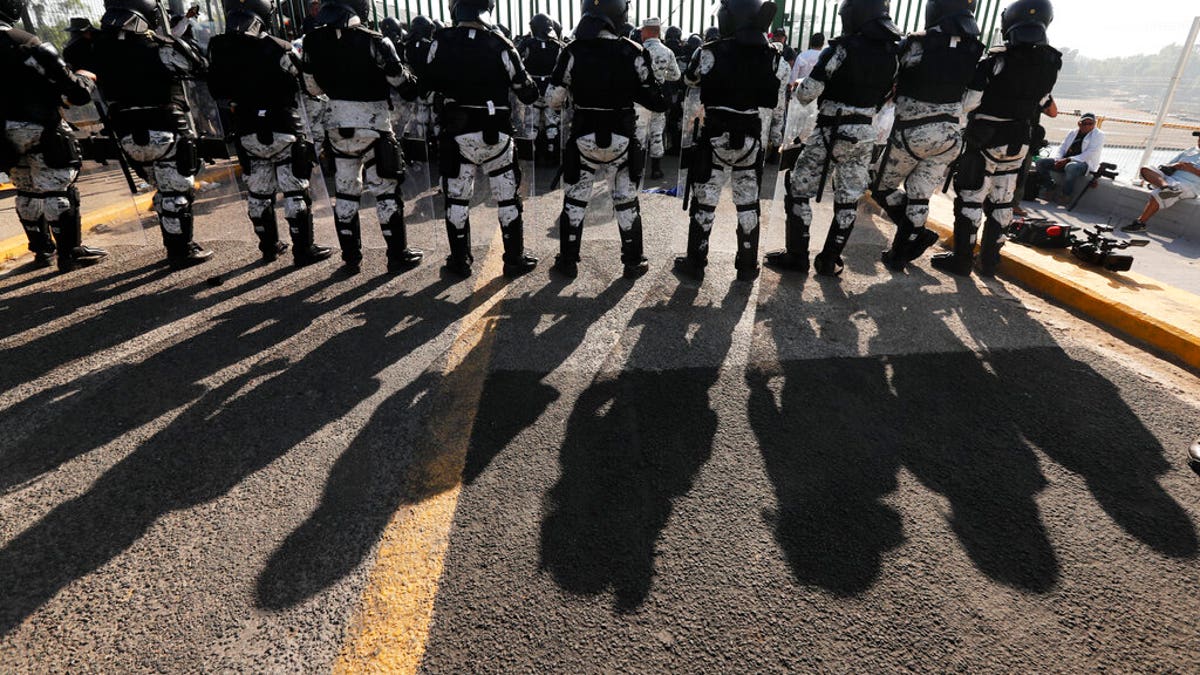 Mexican National Guardsmen block the border crossing between Guatemala and Mexico in Tecun Uman, Guatemala, Saturday, Jan. 18, 2020. More than a thousand Central American migrants surged onto the bridge spanning the Suchiate River, that marks the border between both countries, as Mexican security forces attempted to impede their journey north. (AP Photo/Marco Ugarte)