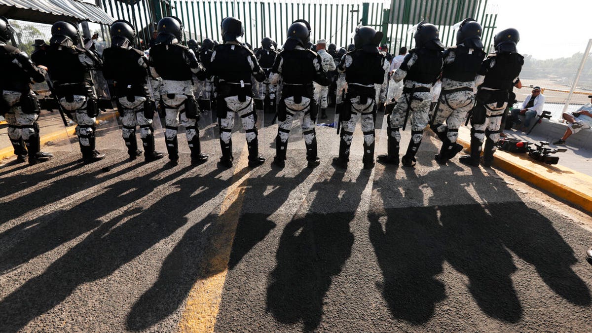 Mexican National Guardsmen block the border crossing between Guatemala and Mexico in Tecun Uman, Guatemala, Saturday, Jan. 18, 2020. More than a thousand Central American migrants surged onto the bridge spanning the Suchiate River, that marks the border between both countries, as Mexican security forces attempted to impede their journey north. (AP Photo/Marco Ugarte)