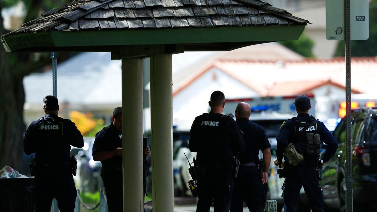 Honolulu police prepare to take defensive positions with their weapons after a shooting and domestic incident at a residence in Honolulu. 