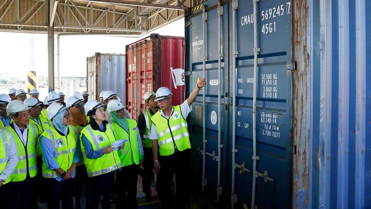Malaysia's Environment Minister Yeo Bee Yin, third from left, inspects a container with plastic waste at a port in Butterworth, Malaysia, Monday, Jan. 20, 2020. 