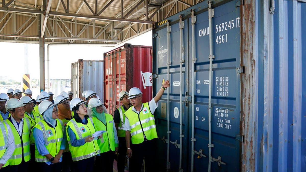 Malaysia's Environment Minister Yeo Bee Yin, third from left, inspects a container with plastic waste at a port in Butterworth, Malaysia, Monday, Jan. 20, 2020.