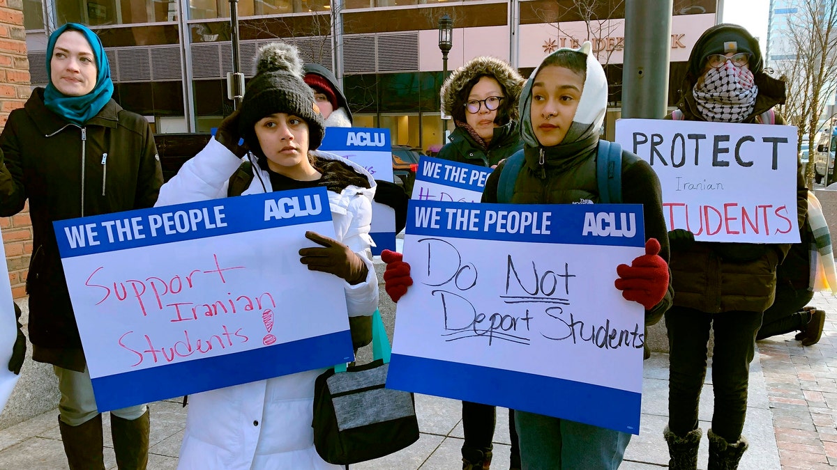 Protesters stand outside the federal courthouse where a hearing was scheduled for Northeastern University student Shahab Dehghani, Tuesday, Jan. 21, 2020, in Boston. Dehghani arrived on a flight into Boston on Monday but was detained by U.S. Customs and Border Patrol at Logan International Airport and then was deported. (AP Photo/Philip Marcelo)