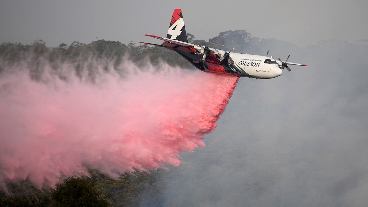 Jan. 10, 2020: Rural Fire Service large air tanker 134, operated by Coulson Aviation in the U.S. state of Oregon, drops fire retardant on a wildfire burning close to homes at Penrose, Australia, 165km south of Sydney. Three American crew members died Thursday when this C-130 Hercules aerial water tanker crashed while battling wildfires in southeastern Australia, officials said. (Dan Himbrechts/AAP Image via AP)