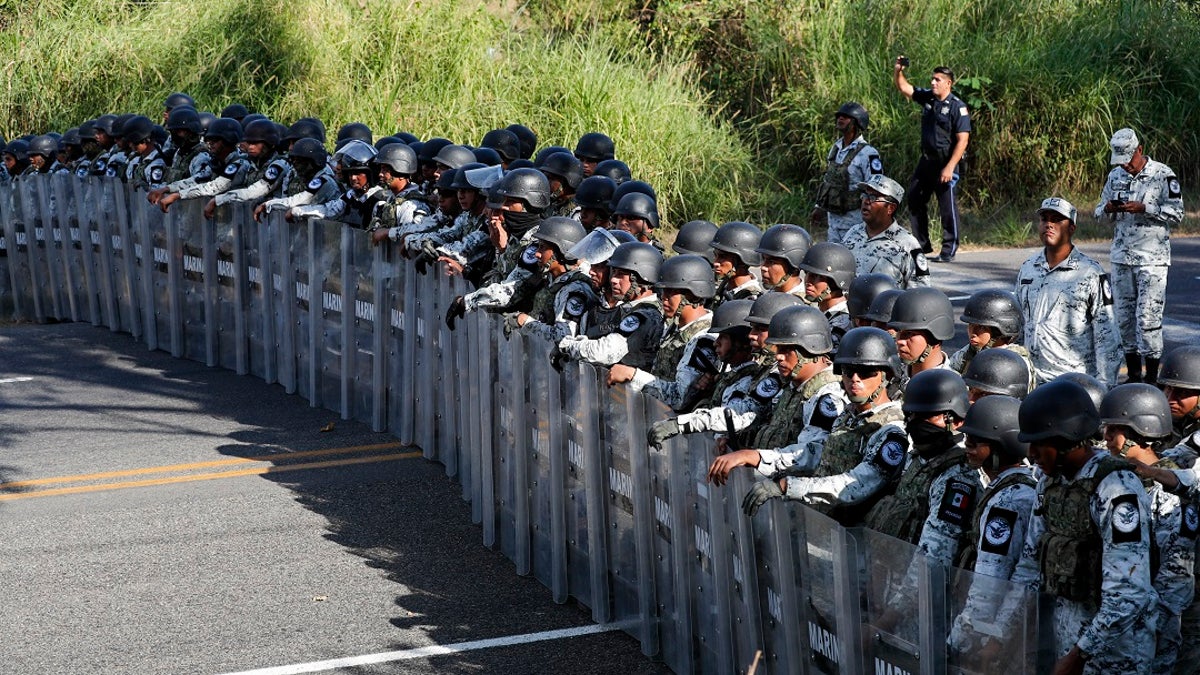 Mexican National Guardsmen block the passage of migrants on the highway leading to Tapachula, Mexico on Thursday. Hundreds of Central American migrants crossed the Suchiate River into Mexico from Guatemala Thursday after a days-long standoff with security forces. (AP Photo/Marco Ugarte)