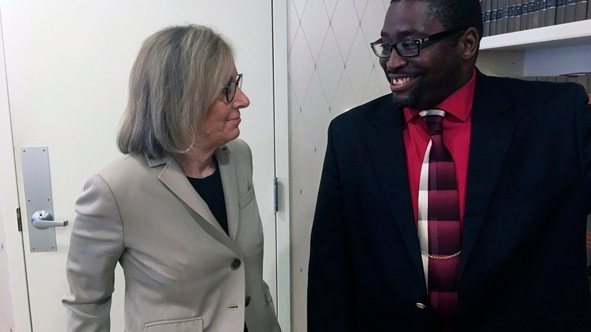 Sauntore Thomas, right, and his lawyer, Deborah Gordon, left, talk Thursday in Bloomfield Hills, Mich. (AP Photo/Mike Householder)