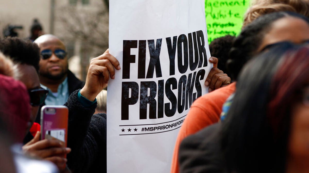 Several attendees waved posters calling for the state to "Fix your prisons," at a rally in front of the Mississippi Capitol in Jackson.