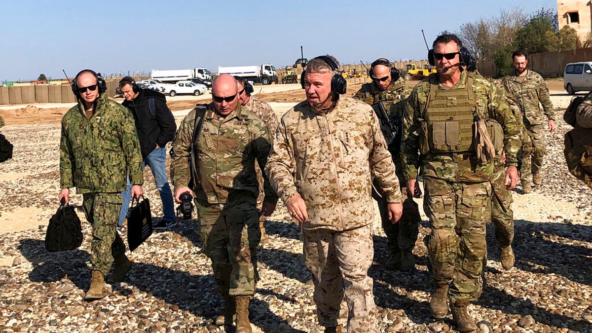 Gen. Frank McKenzie, center front, the top U.S. commander for the Middle East, walks as he visits a military outpost in Syria.