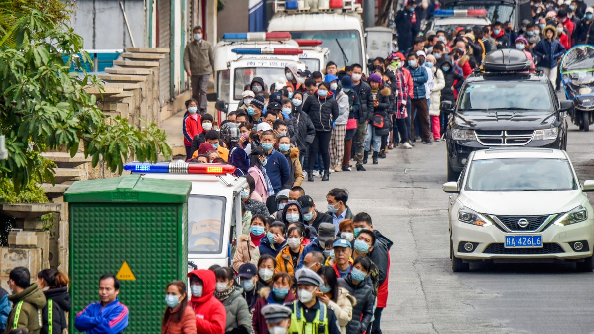 People line up to buy face masks from a medical supply company in Nanning in southern China's Guangxi Zhuang Autonomous Region, Wednesday, Jan. 29, 2020. Countries began evacuating their citizens Wednesday from the Chinese city hardest-hit by a new virus that has now infected more people in China than were sickened in the country by SARS. (Chinatopix via AP)