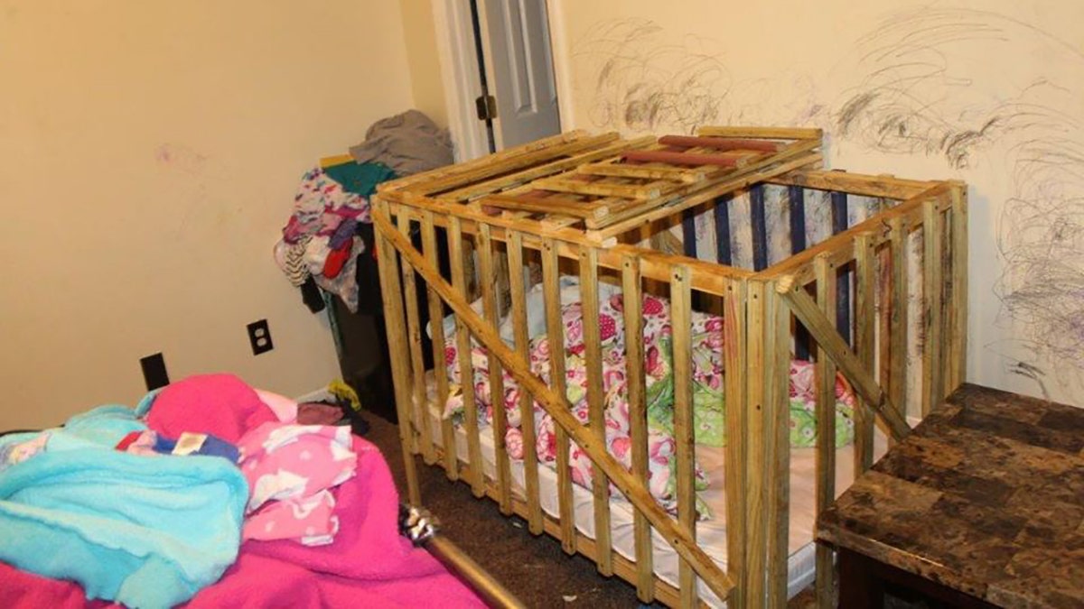 A wooden crib-shaped cage at the home appeared to have a slatted lid that opened and closed.