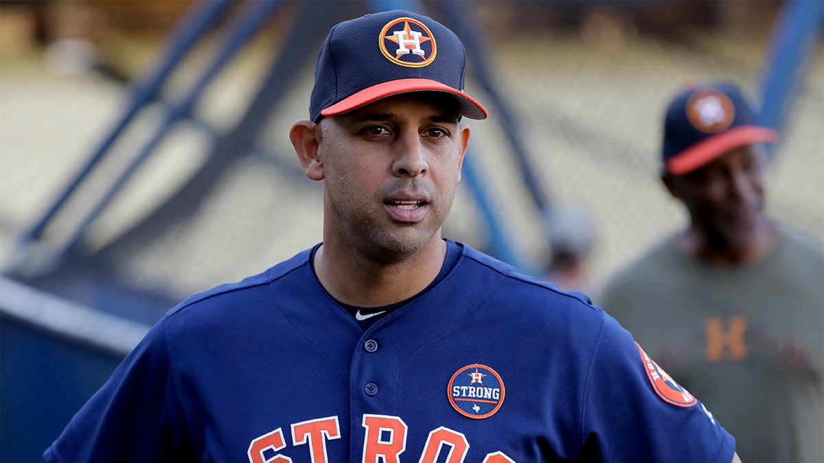 In this Oct. 23, 2017, file photo, Houston Astros bench coach Alex Cora watches batting practice during media day for baseball's World Series against the Los Angeles Dodgers, in Los Angeles. Houston manager AJ Hinch and general manager Jeff Luhnow were suspended for the entire season Monday, Jan. 13, 2020, and the team was fined $5 million for sign-stealing by the team in 2017 and 2018 season. (AP Photo/David J. Phillip, File)