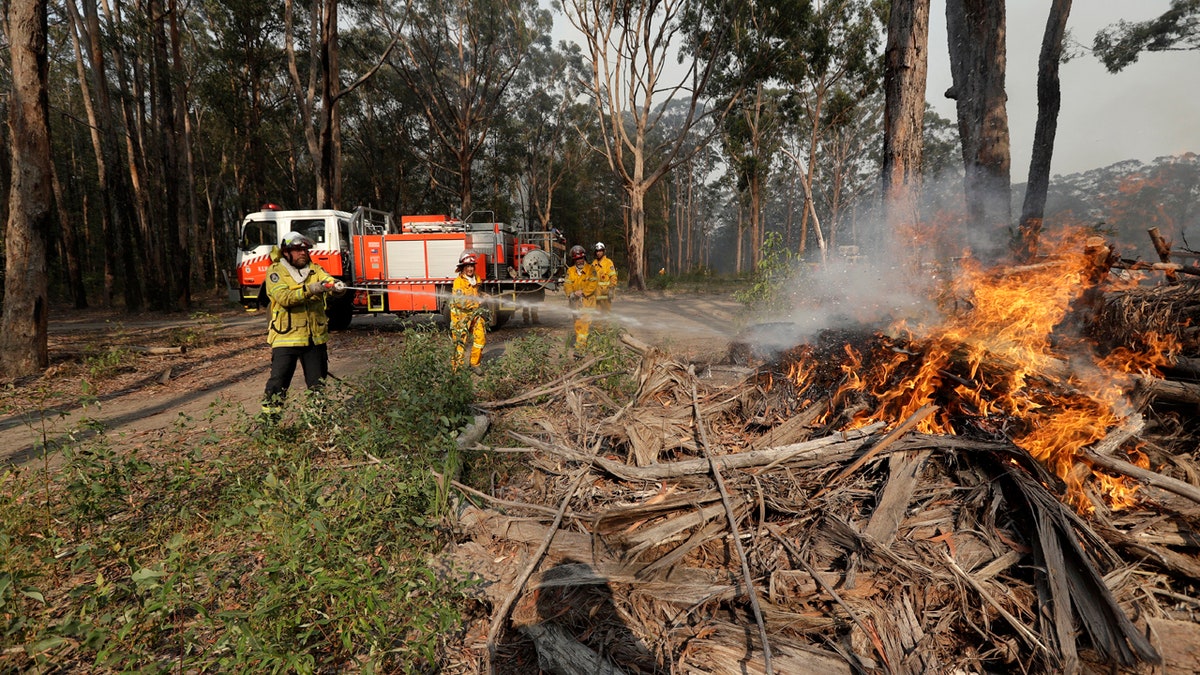 Firefighters battle a fire near Bendalong, Australia, Friday, Jan. 3, 2020.