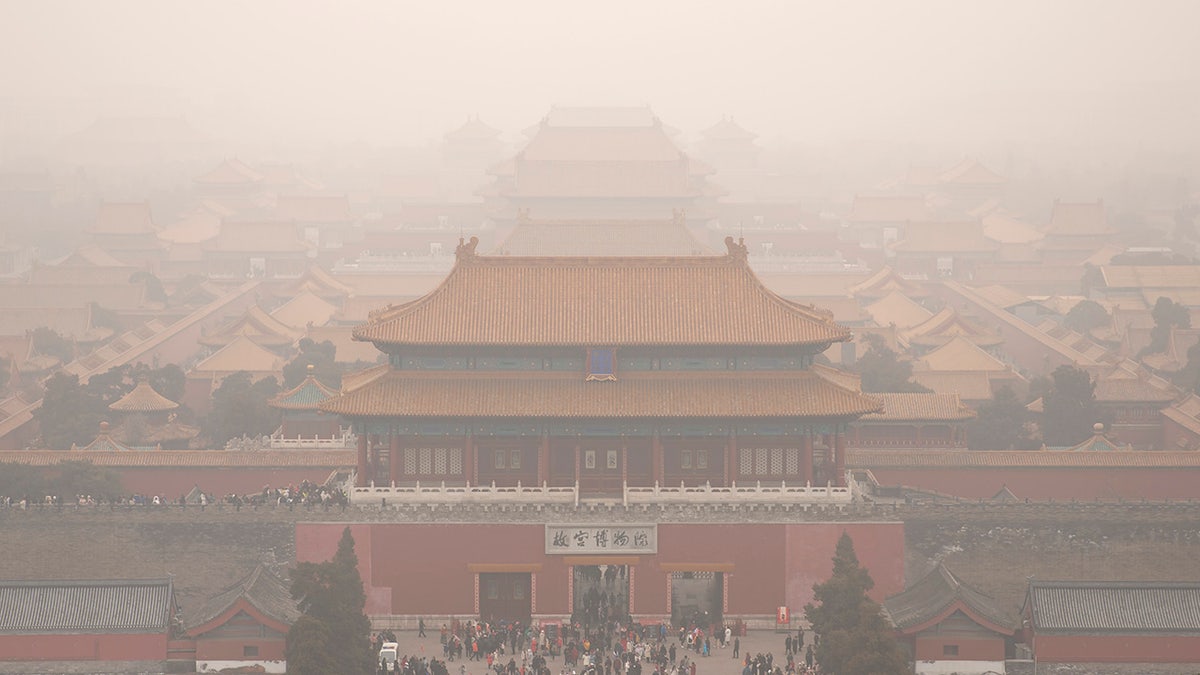 Tourists exit the Forbidden City in Beijing, Saturday, Jan. 18, 2020. A Chinese woman sparked social media outrage in her country by posting photos of herself and a friend with a Mercedes-Benz SUV on the grounds of Beijing's landmark Forbidden City, prompting an apology from the management of China's former imperial palace. (AP Photo/Mark Schiefelbein)