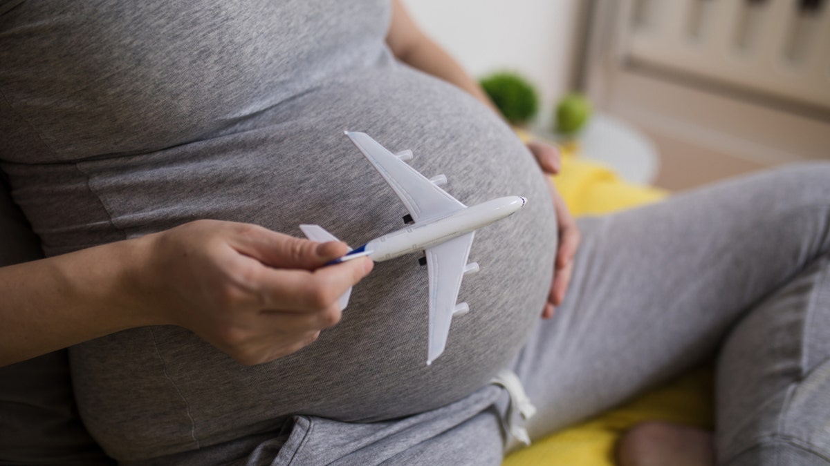 Pregnant woman plays with model airplane