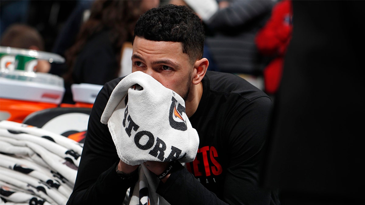 Houston Rockets guard Austin Rivers sits on the bench after word of the death of former NBA star Kobe Bryant before an NBA basketball game against the Denver Nuggets, Sunday, Jan. 26, 2020, in Denver. Bryant died in a California helicopter crash Sunday. (AP Photo/David Zalubowski)