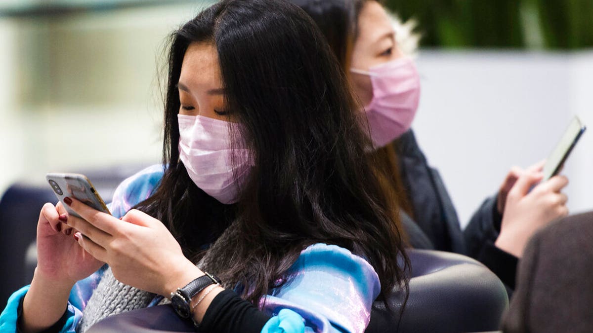 People wear masks following the outbreak of a new virus as people arrive from the International terminal at Toronto Pearson International Airport in Toronto on Saturday, Jan. 25, 2020. A Toronto hospital said Saturday it has a confirmed case of the deadly virus from China, Canada's first. Sunnybrook Health Sciences Centre said it is "caring for a patient who has a confirmed case of the novel coronavirus that originated in Wuhan, China." (Nathan Denette/The Canadian Press via AP)