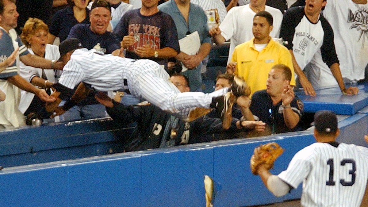 Derek Jeter dives into the stands