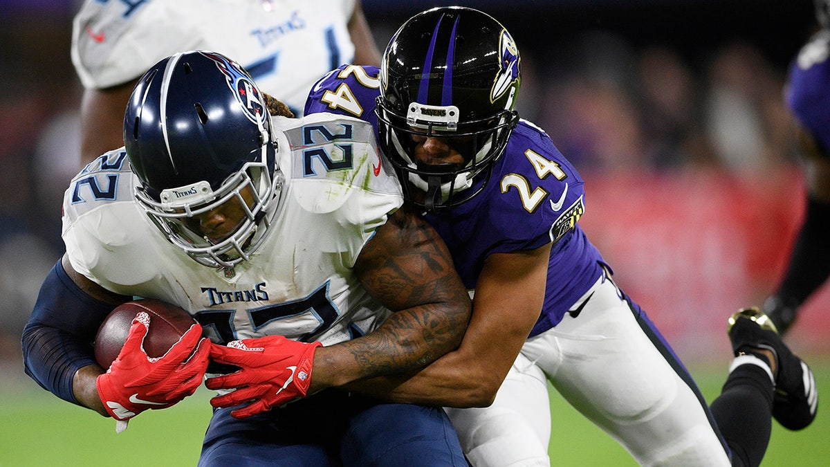 Baltimore Ravens cornerback Marcus Peters (24) hits Tennessee Titans running back Derrick Henry (22) during an NFL divisional playoff football game, Saturday, Jan. 11, 2020, in Baltimore. (AP Photo/Nick Wass)
