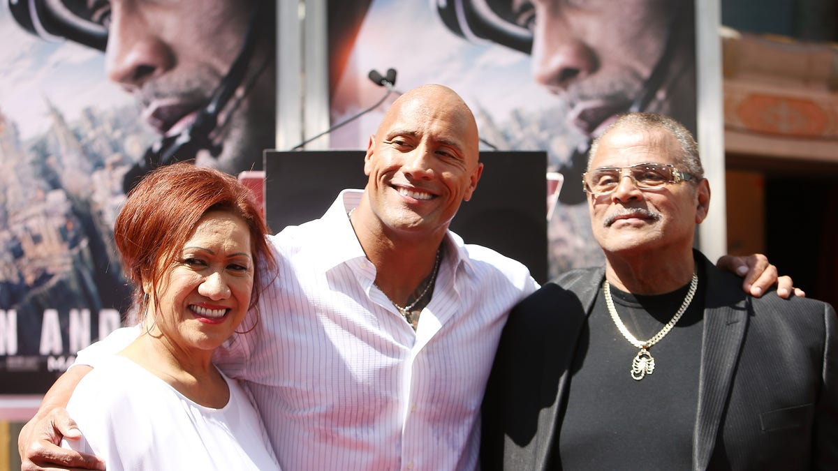 Dwayne "The Rock" Johnson (C) and his mom and dad at the hand/footprint ceremony honoring him in 2015. (Photo by Michael Tran/FilmMagic)
