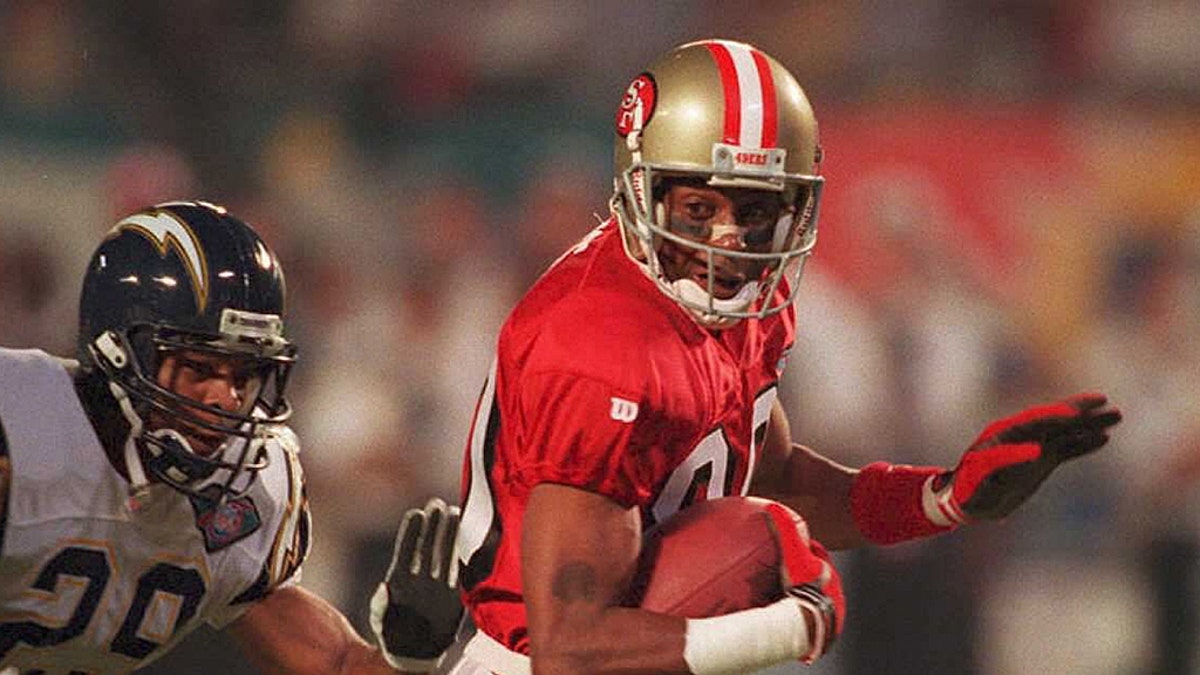 San Francisco 49er wide receiver Jerry Rice (R) runs past San Diego Chargers Stanley Richard (L) and Darren Carrington (C) to score a first-quarter touchdown 29 January 1995 during Super Bowl XXIX at Joe Robbie Stadium in Miami. The touchdown was the earliest scored in Super Bowl history at 1:24 into the game. (AFP via Getty Images)