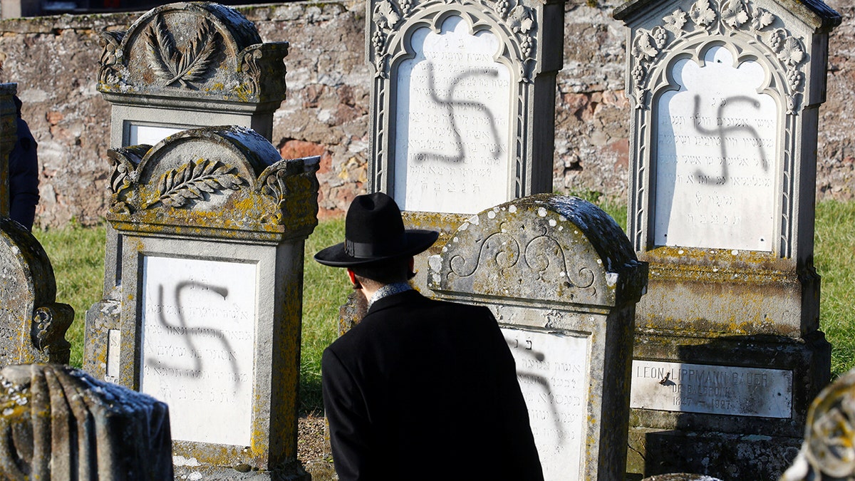 Chief Rabbi Harold Abraham Weill looks at graves desecrated with swastikas at the Jewish cemetery in Westhoffen, near Strasbourg, France, December 4, 2019. (REUTERS/Arnd Wiegmann)