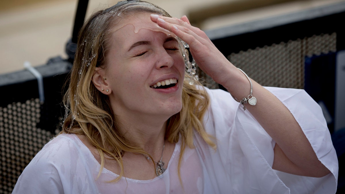 A Christian pilgrim takes part in baptism in the Jordan river during the Orthodox Feast of the Epiphany at Qasr el Yahud, Saturday, Jan. 18, 2020. (AP Photo/Majdi Mohammed)