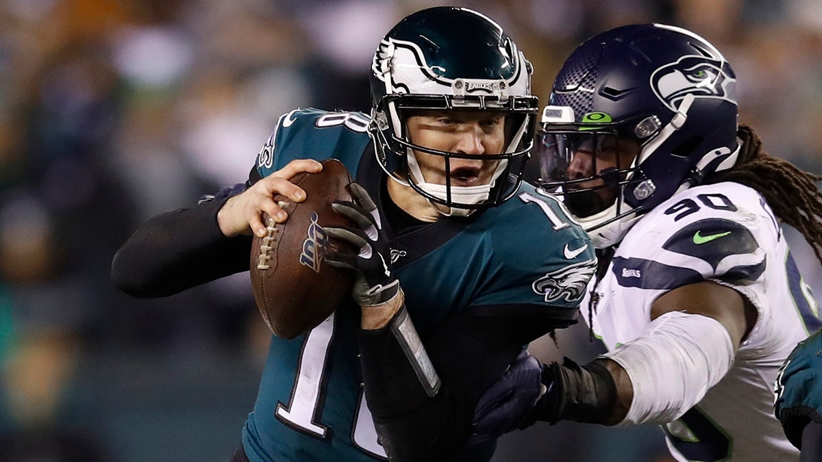 Philadelphia Eagles' Josh McCown (18) tries to get past Seattle Seahawks' Jadeveon Clowney (90) as Miles Sanders (26) tries to defend during the first half of an NFL wild-card playoff football game, Sunday, Jan. 5, 2020, in Philadelphia. (AP Photo/Matt Rourke)