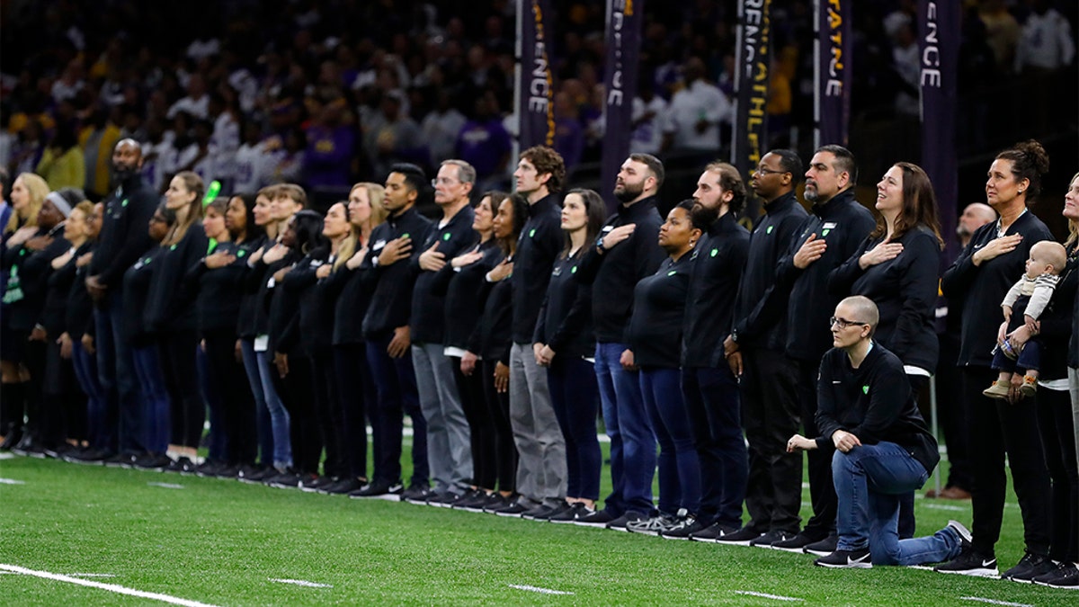 A teacher from the Extra Yard for Teachers charity kneels during the National Anthem prior to the Clemson v LSU game on Jan. 13, 2020 in New Orleans.