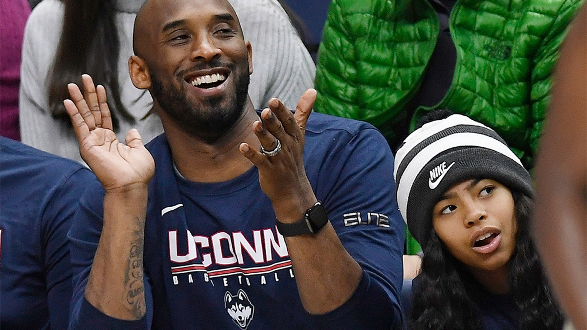 In this March 2, 2019 photo, Kobe Bryant and his daughter Gianna watch the first half of an NCAA college basketball game between Connecticut and Houston in Storrs, Conn. Bryant, the 18-time NBA All-Star who won five championships and became one of the greatest basketball players of his generation during a 20-year career with the Los Angeles Lakers, died in a helicopter crash Sunday, Jan. 26, 2020. Gianna also died in the crash. (AP Photo/Jessica Hill)